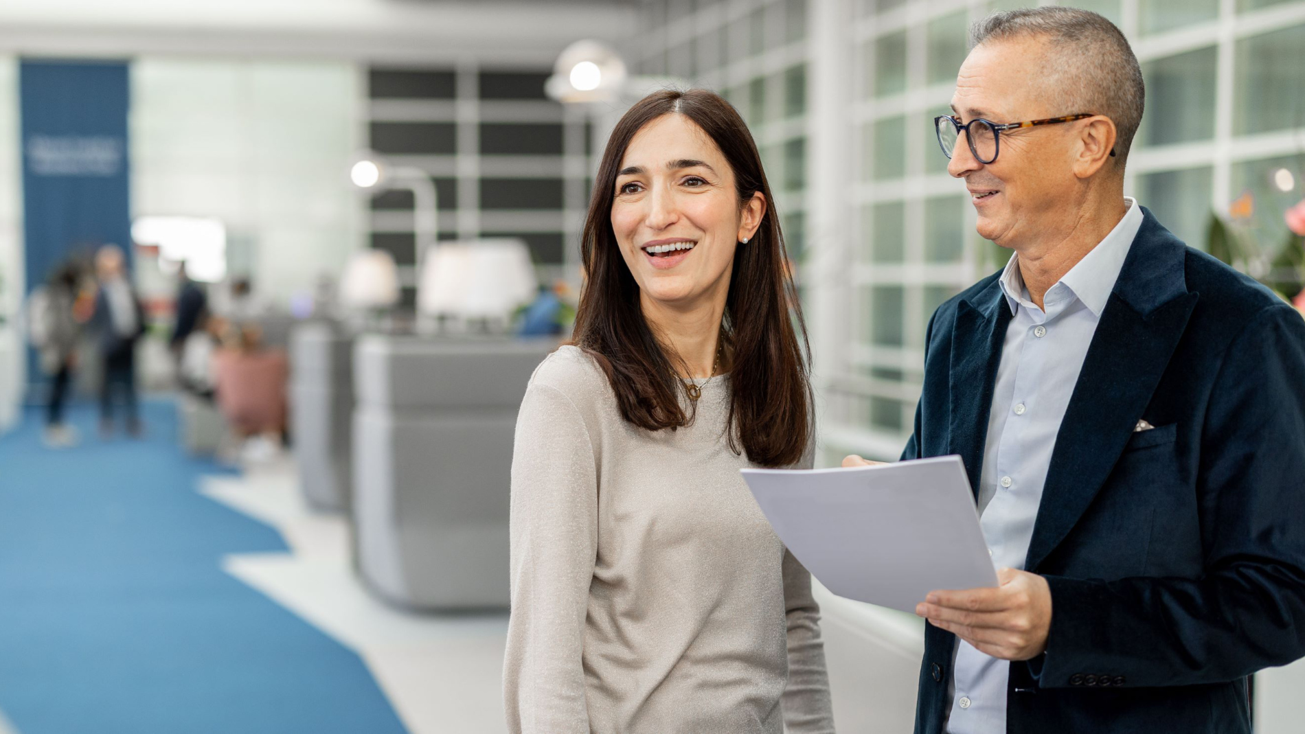A woman and a man are conversing in the business club.
