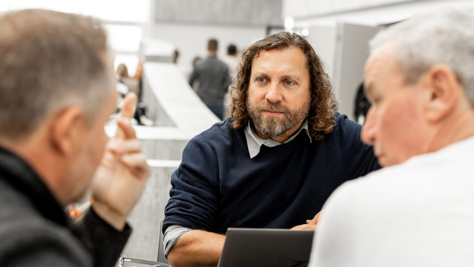 Three men chatting at the Messe Frankfurt Business Club